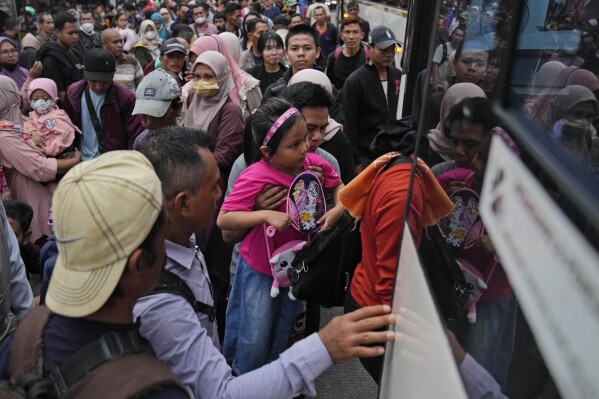 People board a bus as they leave for their hometown ahead of the Eid al-Fitr holiday at Kalideres Bus Terminal in Jakarta, Indonesia, Saturday, April 6, 2024. Millions of Indonesians are packing bus and train stations, airports and highways as they head to hometowns to celebrate Thursday's Eid al-Fitr festival with family. (AP Photo/Dita Alangkara)