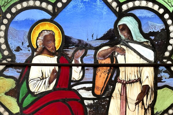 FILE - A detail of a nearly 150-year-old stained-glass window depicts Christ speaking to a Samaritan woman, in the now-closed St. Mark's Episcopal church, Monday, May 1, 2023, in Warren, R.I. The nearly 150-year-old stained-glass church window in Rhode Island that depicts a dark-skinned Jesus Christ interacting with women in New Testament scenes has found a new home at a museum in Tennessee.(AP Photo/Mark Pratt, File)