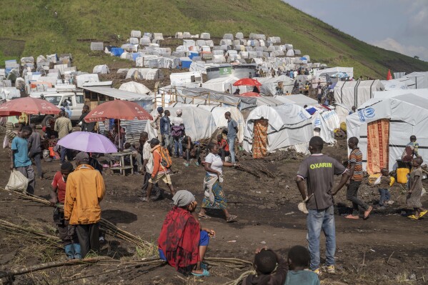 People displaced by the ongoing fighting between Congolese forces and M23 rebels gather in a camp on the outskirts of Goma, Democratic Republic of Congo, Wednesday, March 13, 2024, as OCHA (United Nations Office for the Coordination of Humanitarian Affairs) head and representative Ramesh Rajasingham, carries out a working visit to the region. (AP Photo/Moses Sawasawa)