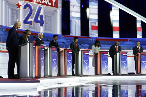 FILE - Republican presidential candidates, from left, former Arkansas Gov. Asa Hutchinson, former New Jersey Gov. Chris Christie, former Vice President Mike Pence, Florida Gov. Ron DeSantis, businessman Vivek Ramaswamy, former U.N. Ambassador Nikki Haley, Sen. Tim Scott, R-S.C., and North Dakota Gov. Doug Burgum stand on stage and listen to a prayer before a Republican presidential primary debate hosted by FOX News Channel, Wednesday, Aug. 23, 2023, in Milwaukee. (AP Photo/Morry Gash, File)