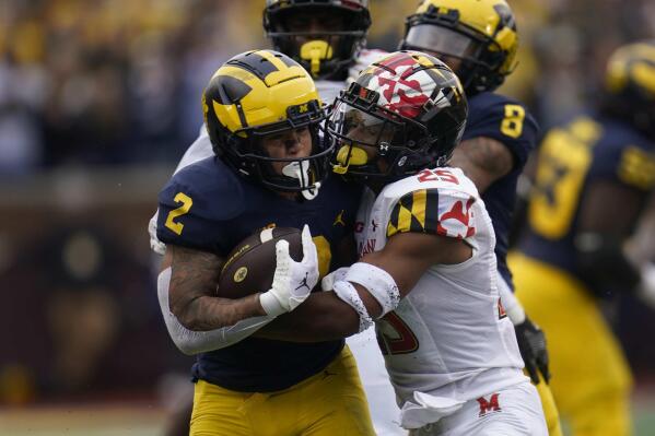 Michigan running back Blake Corum (2) is tackled by Maryland defensive back Beau Brade (25) in the first half of an NCAA college football game in Ann Arbor, Mich., Saturday, Sept. 24, 2022. (AP Photo/Paul Sancya)
