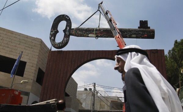 FILE - Palestinians display a huge key, known as 