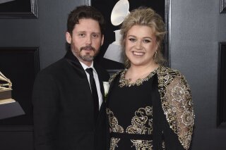 FILE - In this Jan. 28, 2018 file photo shows Kelly Clarkson and her husband Brandon Blackstock at the 60th annual Grammy Awards in New York. Clarkson has filed for divorce from her husband of nearly seven years. The singer, talk show host and judge filed court papers on June 4 in Los Angeles. The 38-year-old Clarkson and the 43-year-old Blackstock have a 5-year-old daughter and a 4-year-old son. (Photo by Evan Agostini/Invision/AP, File)