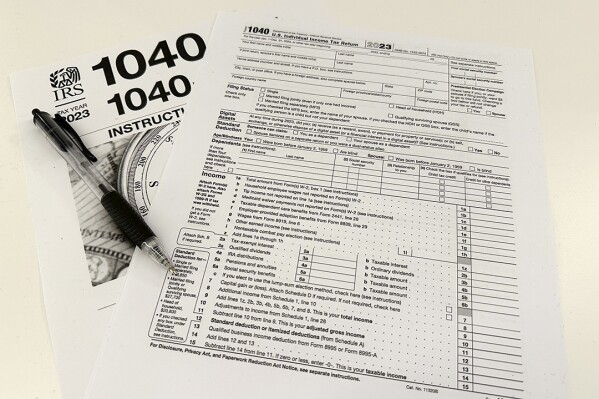FILE - An Internal Revenue Service 2023 1040 tax form and instructions are shown on Jan. 26, 2024 in New York. It's tax season in the U.S., and for many people, filing tax returns can be a daunting task that's often left until the last minute. (Ǻ Photo/Peter Morgan, File)