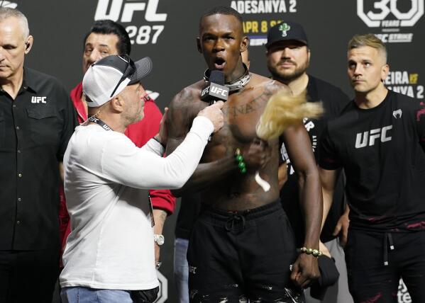 UFC commentator Joe Rogan, front left, listens to Israel Adesanya after a ceremonial weigh-in Friday, April 7, 2023, in Miami. Adesanya will face UFC 287 middleweight champion Alex Pereira on Saturday. (AP Photo/Marta Lavandier)