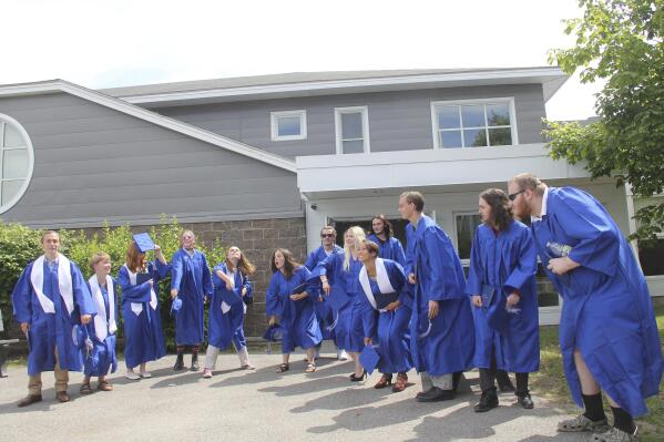 In this June 13, 2021 photo provided by Melissa Burns, Islesboro Central School seniors prepare to toss their mortarboards to celebrate their graduation. The Class of 2021 – all 13 of them – were eyeing a trip to Greece, or maybe South Korea, but they wound up going nowhere. The seniors decided to donate $5,000 to help out struggling neighbors after the coronavirus pandemic changed everything. (Melissa Burns via AP)