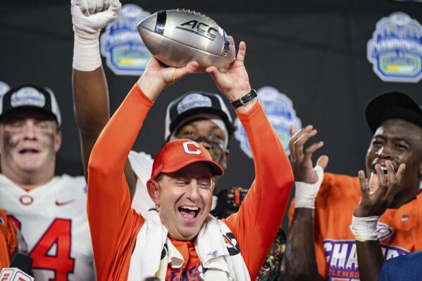 Clemson coach Dabo Swinney holds up the trophy after the team's win over North Carolina in the Atlantic Coast Conference championship NCAA college football game Saturday, Dec. 3, 2022, in Charlotte, N.C. (AP Photo/Jacob Kupferman)