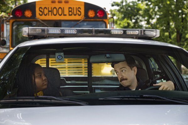 This image released by Netflix shows Terrence Little Gardenhigh, left, and Ed Helms in a scene from "Coffee & Kareem." (Justina Mintz/Netflix via AP)