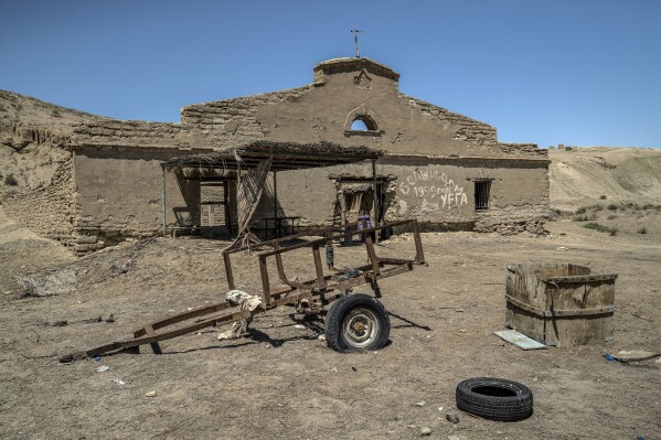 An abandoned fishing workshop is visible along the dried-up area of the Aral Sea in Uzbekistan, Saturday, June 24, 2023. (AP Photo/Ebrahim Noroozi)