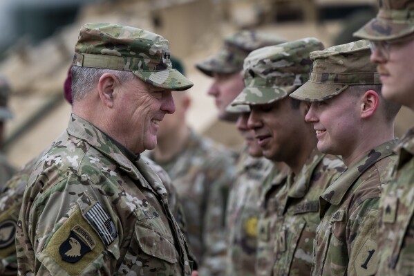 FILE - Chairman of the Joint Chiefs of Staff Gen. Mark Milley greets a soldier of the U.S. Army, at the Training Range in Pabrade, some 60km.(38 miles) north of the capital Vilnius, Lithuania, Sunday, March 6, 2022. (AP Photo/Mindaugas Kulbis, File)