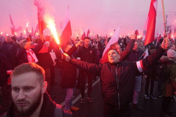 People hold flares as they take part in a yearly march on Poland's Independence Day holiday in Warsaw, Poland, on Saturday, Nov. 11, 2023. The Independence Day holiday celebrates the restoration of Poland's national sovereignty in 1918, at the end of World War I and after 123 years of foreign rule. (AP Photo/Czarek Sokolowski)