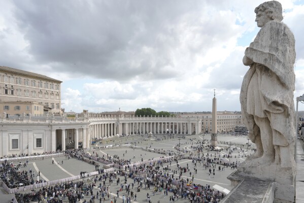 People arrive at St. Peter's Square at the Vatican where 133 cardinals gather on the second day of the conclave to elect successor of late Pope Francis, Thursday, May 8, 2025. (AP Photo/Markus Schreiber)