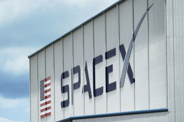FILE - The SpaceX logo is displayed on a building, May 26, 2020, at the Kennedy Space Center in Cape Canaveral, Fla. On Wednesday, Jan. 3, 2024, a U.S. labor agency accused SpaceX of unlawfully firing employees who penned an open letter critical of CEO Elon Musk and creating an impression that worker activities were under surveillance by the rocket ship company. (AP Photo/David J. Phillip, File)