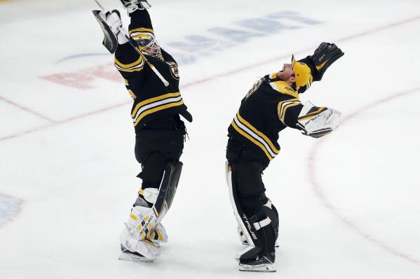 Boston Bruins' Linus Ullmark, left, celebrates with Jeremy Swayman after defeating the New York Islanders in an NHL hockey game, Saturday, March 26, 2022, in Boston. (AP Photo/Michael Dwyer)