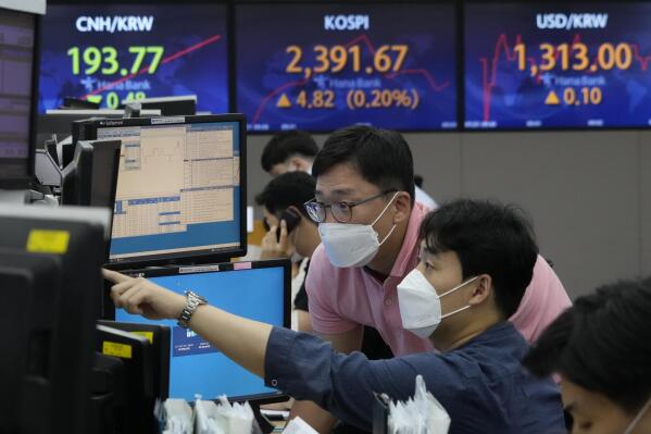 Currency traders watch monitors at the foreign exchange dealing room of the KEB Hana Bank headquarters in Seoul, South Korea, Thursday, July 21, 2022. Asian shares mostly slipped Thursday, as optimism was tempered by persistent concerns about inflation and the Chinese economy, despite the rally on Wall Street. (AP Photo/Ahn Young-joon)