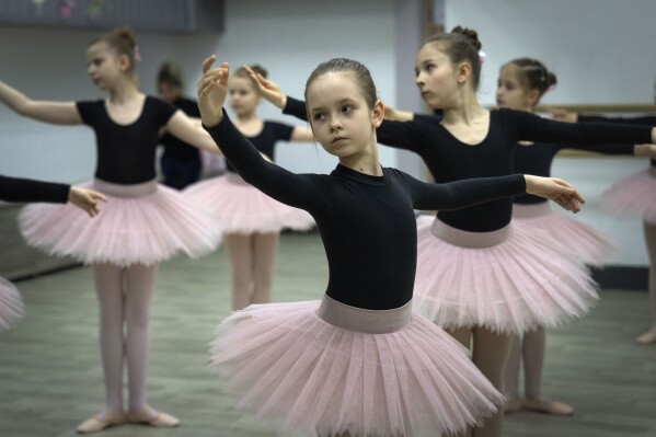 Girls practice in a ballet studio in a bomb shelter in Kharkiv, Ukraine, Monday, March 18, 2024. In northeast Ukraine, a dance studio that doubles as a bomb shelter is an escape from the horrors of war for about 20 young girls. The Princess Ballet Studio in Kharkiv is a spartan, windowless room, but practicing underground means they can dance through the almost hourly air raid alerts. (AP Photo/Efrem Lukatsky)