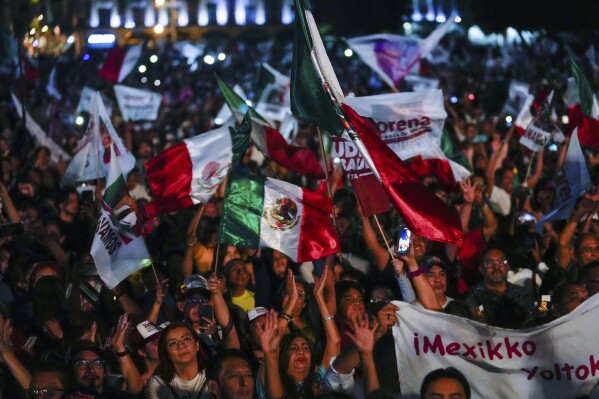 Supporters of ruling party presidential candidate Claudia Sheinbaum celebrate at the Zocalo, Mexico City's main square, after the National Electoral Institute announced she held an irreversible lead in the election, early Monday, June 3, 2024. (AP Photo/Matias Delacroix)