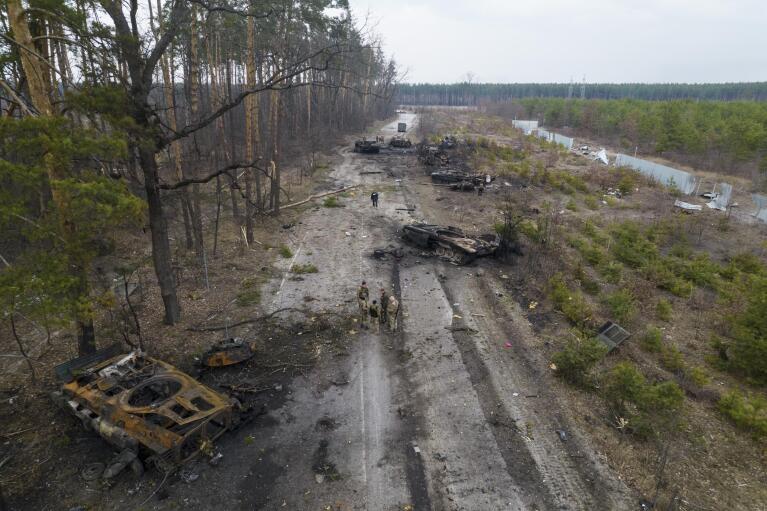 Ukrainian soldiers stand amid destroyed Russian armored vehicles in the outskirts of Kyiv, Ukraine, on Thursday, March 31, 2022. Russian forces shelled Kyiv’s suburbs, two days after the Kremlin said it would significantly scale back operations near both the capital and the northern city of Chernihiv after its forces met with stiff resistance. Russian President Vladimir Putin, who started the war on Feb. 24, 2022, and could end it at any time, still appears determined to prevail -- ruthlessly and at all costs. (AP Photo/Rodrigo Abd, File)