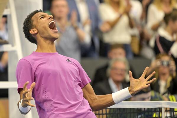 Canada's Felix Auger-Aliassime cheers after winning the final match against Denmark's Holger Rune at the Swiss Indoors tennis tournament at the St. Jakobshalle in Basel, Switzerland, on Sunday, October 30, 2022. (Georgios Kefalas/Keystone via AP)