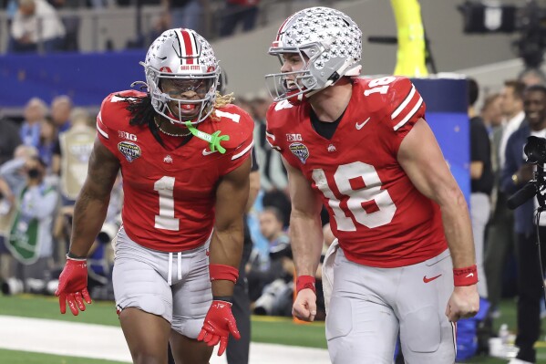 Ohio State running back Quinshon Judkins (1) celebrates after scoring a touchdown with quarterback Will Howard (18) during the second half of the Cotton Bowl College Football Playoff semifinal game against Texas, Friday, Jan. 10, 2025, in Arlington, Texas. (AP Photo/Gareth Patterson)