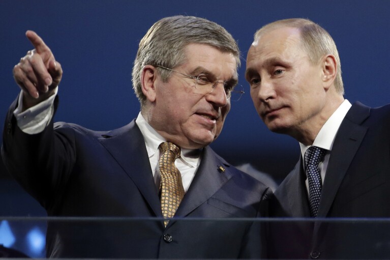 FILE - International Olympic Committee President Thomas Bach, left, and Russian President Vladimir Putin watch the closing ceremony of the 2014 Winter Olympics, in Sochi, Russia, on Sunday, Feb. 23, 2014. Russia sought to impress the world and expand its global prestige by hosting the expensive Olympics ever. (AP Photo/Charlie Riedel, File)
