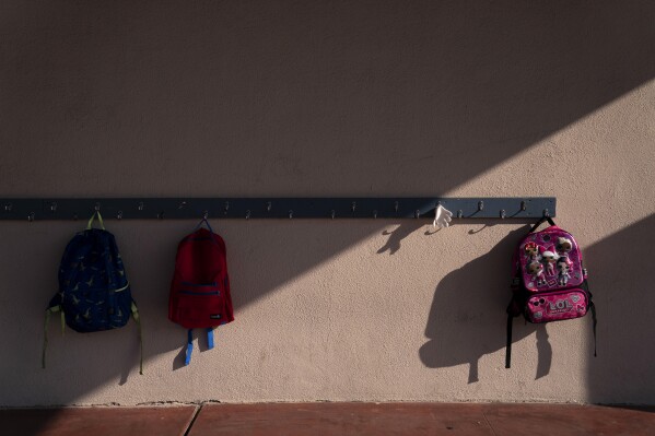 School backpacks hang on a rack at West Orange Elementary School in Orange, Calif., March 18, 2021. (AP Photo/Jae C. Hong)