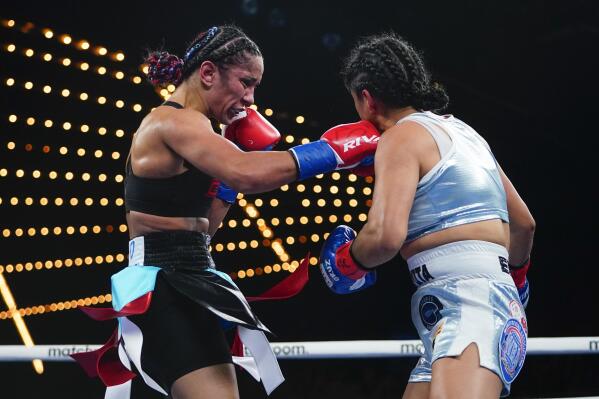 Puerto Rico's Amanda Serrano, left, punches Mexico's Erika Cruz Hernandez during the third round of a women's featherweight championship boxing bout Saturday, Feb. 4, 2023 in New York. Serrano won the fight. (AP Photo/Frank Franklin II)