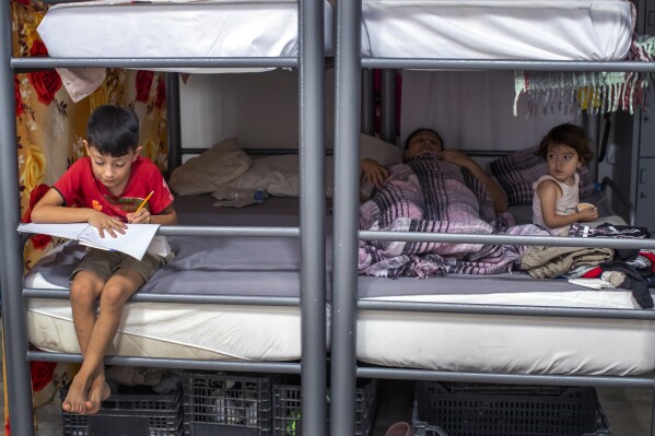 Brayan, 8, and his sister, Linda, 3, sit with their mother at a church-run shelter in Ciudad Juarez, Mexico, while waiting for Customs and Border Protection approval to cross into El Paso, Texas, on Friday, Aug. 9, 2024. (AP Photo/Andres Leighton)