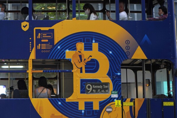 FILE - An advertisement for the cryptocurrency Bitcoin displayed on a tram, May 12, 2021, in Hong Kong. U.S. regulators are soon expected to decide whether to approve the first bitcoin exchange-traded fund, a development that could thrust the once niche and nerdy corner of the internet even further into the financial mainstream. (AP Photo/Kin Cheung, File)