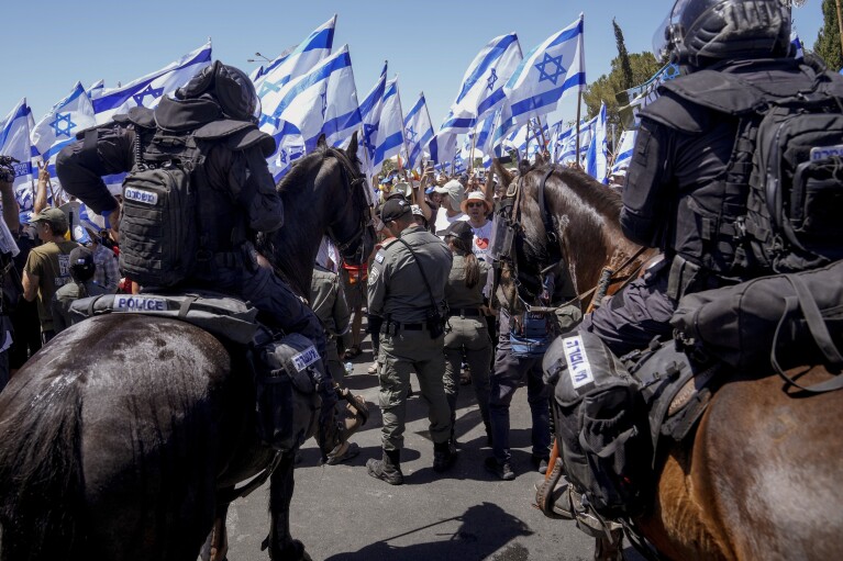 Israeli police disperse demonstrators blocking the road leading to the Knesset, Israel's parliament, during a protest against plans by Prime Minister Benjamin Netanyahu's government to overhaul the judicial system, in Jerusalem, Monday, July 24, 2023. (AP Photo/Mahmoud Illean)