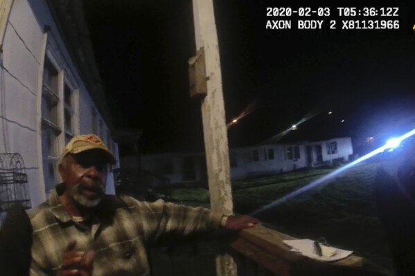 In this image from Birmingham Police Department body-camera video, Carl Grant sits on the porch of a stranger’s home in Birmingham, Ala., after police were called there on Feb. 2, 2020. Grant, a Vietnam War veteran with dementia, went out to shop for groceries near his suburban Atlanta home but became disoriented and ended up driving over two hours away. Police were called when he tried to get inside houses in Birmingham that he thought were his. (Birmingham Police Department via AP)