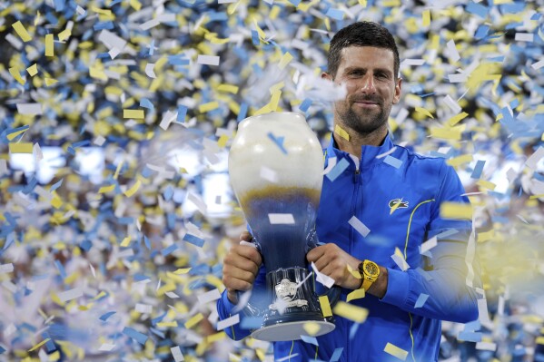Novak Djokovic, of Serbia, celebrates with the Rookwood Cup as he poses for photos after defeating Carlos Alcaraz, of Spain, during the men's singles final of the Western & Southern Open tennis tournament, Sunday, Aug. 20, 2023, in Mason, Ohio. (AP Photo/Aaron Doster)