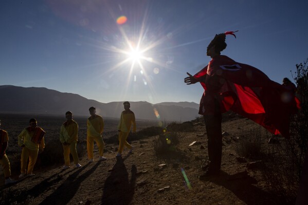 FILE - A youth dressed as a shaman arrives to take part in a photo session before Tuesday's total solar eclipse, in La Higuera, Chile, Monday, July 1, 2019. (AP Photo/Esteban Felix, File)