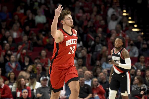 Houston Rockets center Alperen Sengun, left, reacts after hitting a 3-point shot against the Portland Trail Blazers during the second half of an NBA basketball game in Portland, Ore., Saturday, March 26, 2022. The Rockets won 115-98. (AP Photo/Steve Dykes)