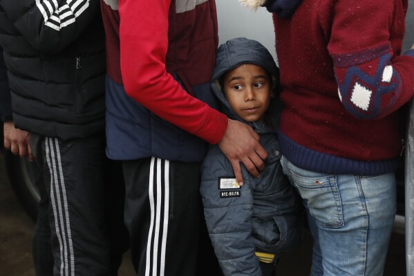 FILE - Migrants wait in line for a distribution of blankets close to the Turkish-Greek border near Pazarkule, Edirne region, Turkey, Tuesday, March 10, 2020. European Union auditors said on Wednesday, April 24, 2024, they are unable to establish whether some of the billions of euros the bloc has given to Turkey to help it cope with Syrian refugees is actually having any impact. EU leaders and Turkey in 2016, committed to provide at least 6 billion euros ($6.4 billion) to Turkey to help it cope with migrants crossing in from Syria. (AP Photo/Darko Bandic, File)