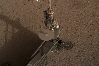This photo provided by NASA/JPL-Caltech shows an image acquired by NASA's InSight Mars lander using its robotic arm-mounted, Instrument Deployment Camera (IDC). The image was acquired on March 1, 2019, Sol 92 where the local mean solar time for the image exposures was 16:53:31.055 PM. Scientists say NASA's newest Mars lander has started digging into the red planet, but has hit a few snags. (NASA/JPL-Caltech via AP)