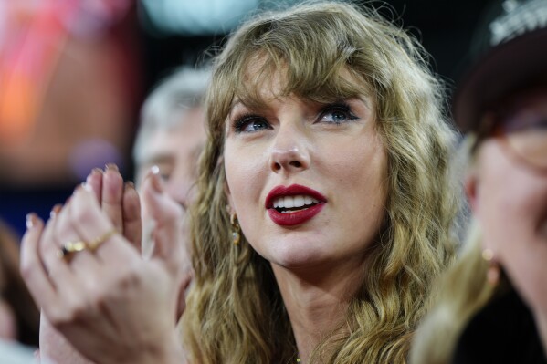 FILE - Taylor Swift stands on the field after an AFC Championship NFL football game between the Baltimore Ravens and the Kansas City Chiefs, Sunday, Jan. 28, 2024, in Baltimore. Taylor Swift, who is holding concerts in Japan, will make it in time for the Super Bowl to see her partner and football superstar Travis Kelce play. (AP Photo/Julio Cortez, File)