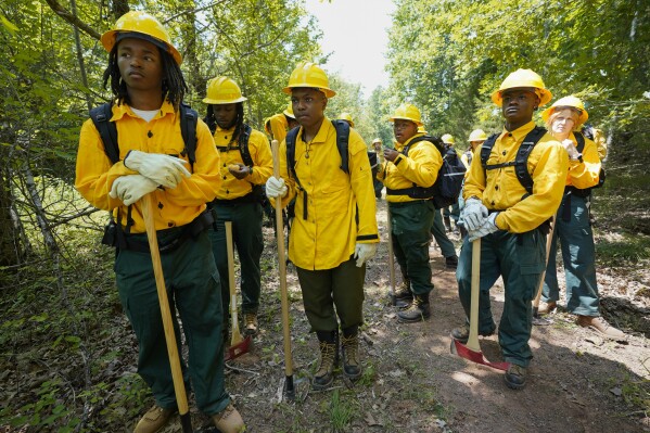 Wildland firefighter students from Alabama A&M and Tuskegee universities listen during a wildland firefighter training Friday, June 9, 2023, in Hazel Green, Ala. A partnership between the U.S. Forest Service and four historically Black colleges and universities is opening the eyes of students of color who had never pictured themselves as fighting forest fires. (AP Photo/George Walker IV)