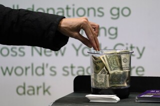 FILE - Money is donated for out of work musicians on March 18, 2021, in New York. At tax time, the three biggest potential deductions for most people are mortgage insurance, charitable donations in cash or in property, and eligible state and local taxes. (AP Photo/Kathy Willens, File)