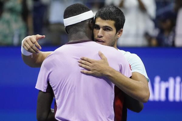 Carlos Alcaraz, of Spain, right, hugs Frances Tiafoe, of the United States, after winning their semifinal match of the U.S. Open tennis championships, Friday, Sept. 9, 2022, in New York. (AP Photo/John Minchillo)