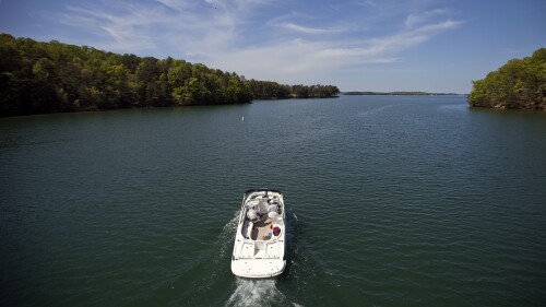 FILE - A boat passes along Lake Lanier, April 23, 2013, in Buford, Ga. Fashion designer Tameka Foster, the ex-wife of R&B singer Usher, is calling to drain Lake Lanier, Georgia's largest lake, where her son was fatally injured 11 years ago. Kile Glover, her 11-year-old son with Bounce TV chairman Ryan Glover, died in July 2012 after a personal watercraft struck the boy as he floated in an inner tube on the lake. (AP Photo/David Goldman, File)
