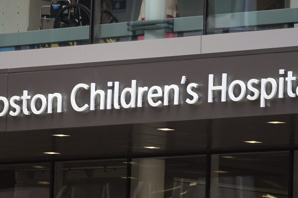 A sign hangs on the Boston Children's Hospital, Thursday, Aug. 18, 2022, in Boston. A Massachusetts woman pleaded guilty on Thursday, Sept. 28, 2023, to calling in a fake bomb threat to Boston Children’s Hospital as it faced a barrage of harassment over its surgical program for transgender youths. (AP Photo/Charles Krupa)