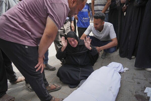 Hanan Al-Aloul mourns over the body of a relative killed earlier when an Israeli army strike hit their home, during before the funeral outside al-Shifa hospital in Gaza City, Sunday, May 18, 2025. (AP Photo/Jehad Alshrafi)
