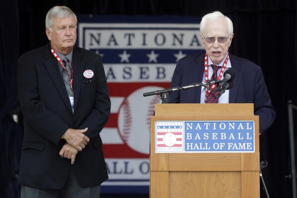FILE - Dr. Frank Jobe, right, known for the development of the historic elbow procedure known as "Tommy John Surgery," speaks as he and Tommy John, left, are honored during a ceremony at Doubleday Field at the National Baseball Hall of Fame in Cooperstown, N.Y. , July 27, 2013. . (AP Photo/Mike Groll, File)