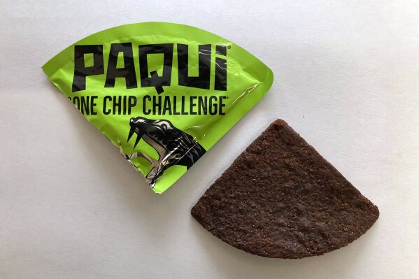 FILE - A Paqui One Chip Challenge chip is displayed in Boston, Friday, Sept. 8, 2023. A medical examiner says a Massachusetts teen who participated in a spicy tortilla chip challenge died from ingesting a substance “with a high capsaicin concentration,” according to autopsy results The Associated Press obtained late Wednesday, May 15, 2024. Capsaicin is a chili pepper extract. Harris Wolobah died on Sept. 1, 2023, after eating the chip. (AP Photo/Steve LeBlanc, File)