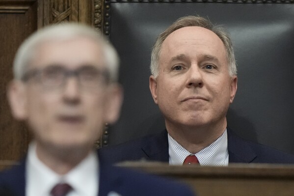FILE - Speaker of the Assembly Robin Vos watches as Wisconsin Gov. Tony Evers speaks during the annual State of the State address, Jan. 24, 2023, in Madison, Wis. The Republican speaker of the Wisconsin Assembly is promising to vote against pay raises for University of Wisconsin employees unless the university cuts diversity, equity and inclusion spending by $32 million, a move that comes as the Democratic governor is calling on lawmakers to spend even more on higher education. (AP Photo/Morry Gash, file)