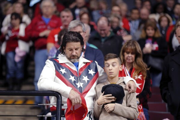 A man dressed as Evel Knievel prays with a boy prays during the invocation at the start of a campaign rally for President Donald Trump in Bossier City, La., Thursday, Nov. 14, 2019. (AP Photo/Gerald Herbert)