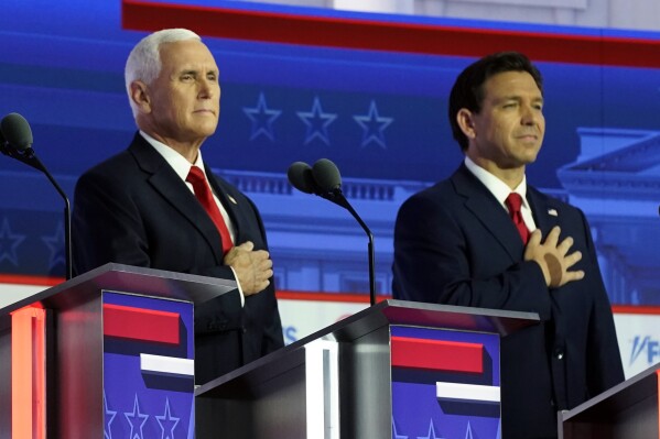Republican presidential candidates former Vice President Mike Pence and Florida Gov. Ron DeSantis stand on stage before a Republican presidential primary debate hosted by FOX News Channel Wednesday, Aug. 23, 2023, in Milwaukee. (AP Photo/Morry Gash)