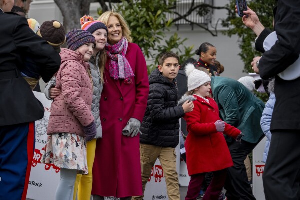 First lady Jill Biden takes a photo with guests during a Toys for Tots event with local Marine Corps and military-connected families on the South Lawn of the White House, Wednesday, Dec. 6, 2023, in Washington. (AP Photo/Andrew Harnik)