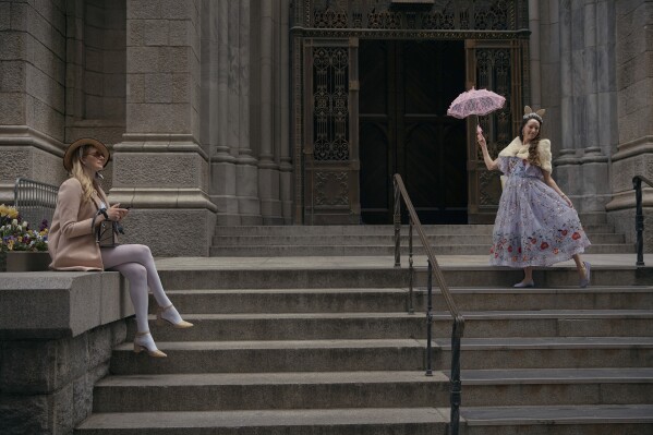Revelers wearing decorated hats and costumes pose and take a break during the annual Easter Parade and Bonnet Festival in front of St. Patrick's Cathedral on Sunday, April 20, 2025, in New York. (AP Photo/Andres Kudacki)